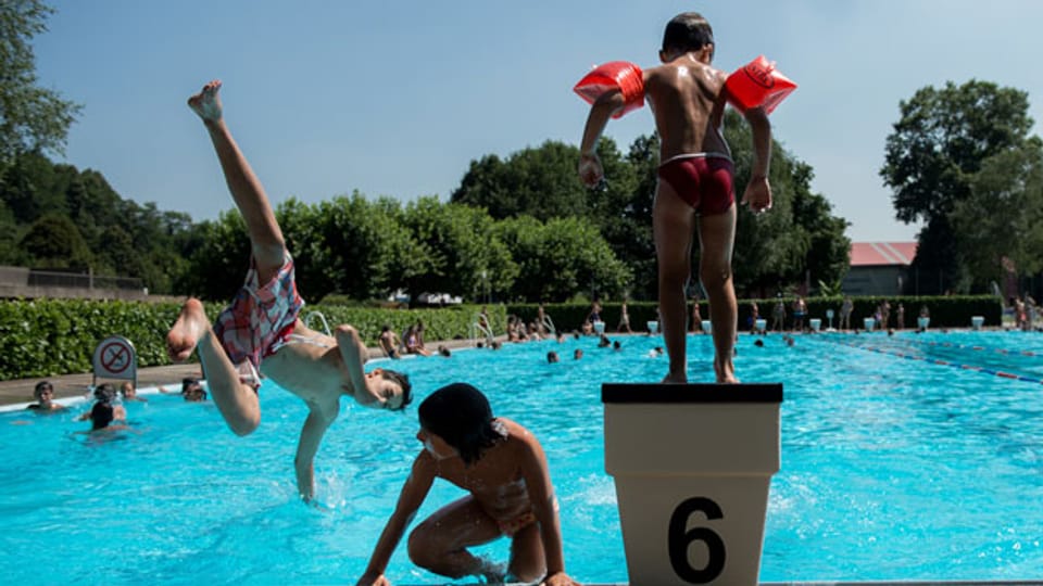 Kinder erfrischen sich im Schwimmbad in Mendrisio.