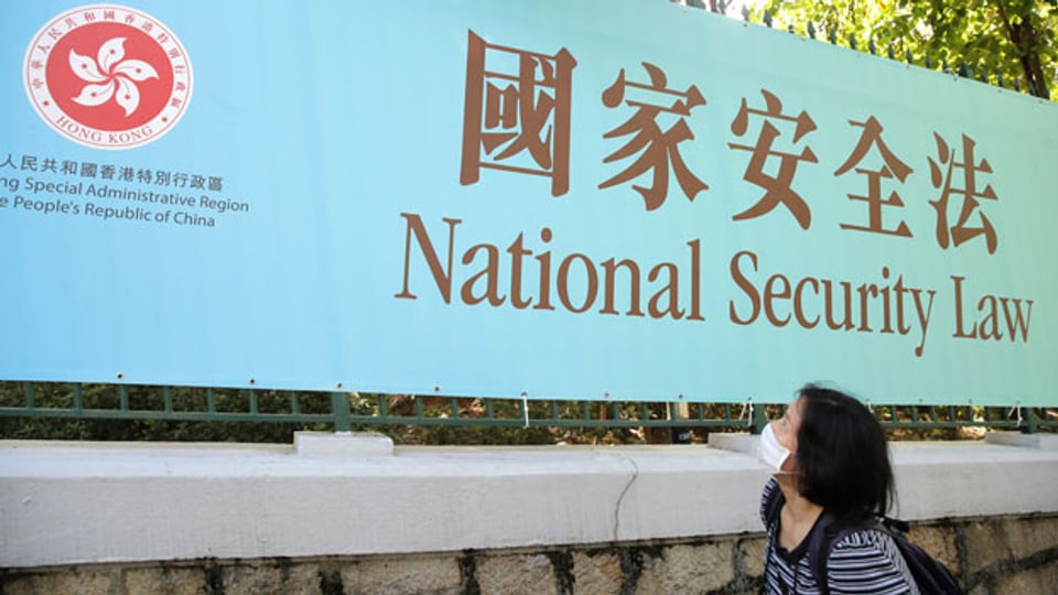 Eine Frau geht am 30. Juni 2020 in Hongkong an einem Werbebanner für das nationale Sicherheitsgesetz für Hongkong vorbei.
