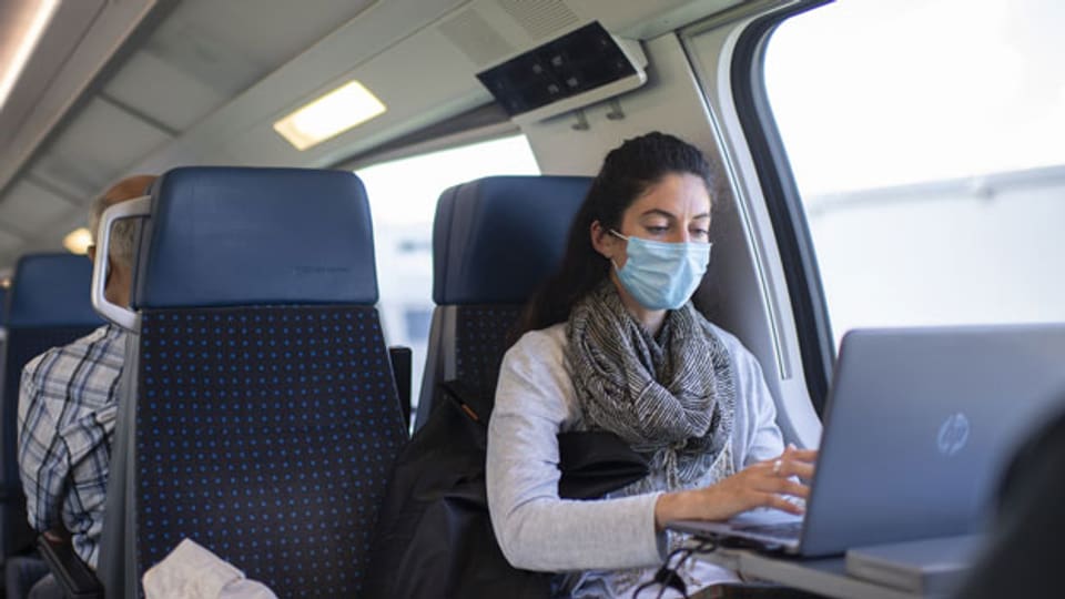 Eine Frau mit Schutzmaske im Zug der SBB.
