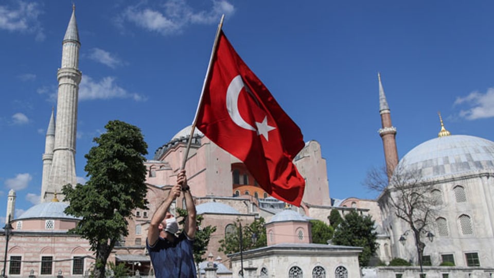 Ein Mann hält eine türkische Flagge vor dem Hagia-Sophia-Museum in Istanbul, Türkei, 10. Juli 2020.