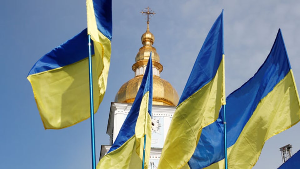 Ukrainische Flaggen vor der St. Michaelis-Kathedrale mit goldener Kuppel in Kiew.