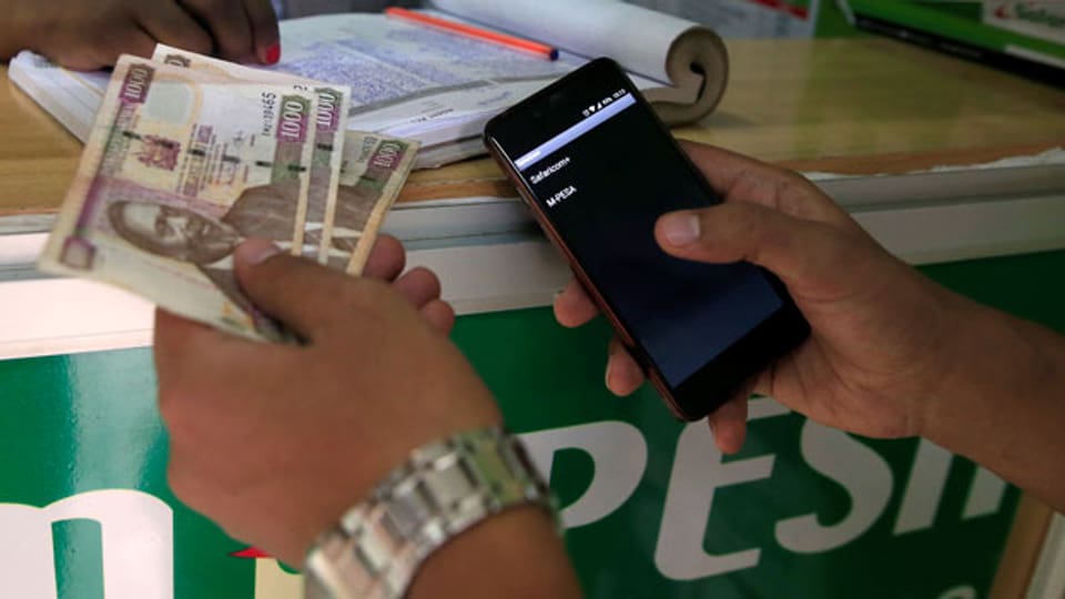 Ein Kunde macht eine Geldüberweisung mit seinem Mobilephone mit M-Pesa in Nairobi, Kenia.