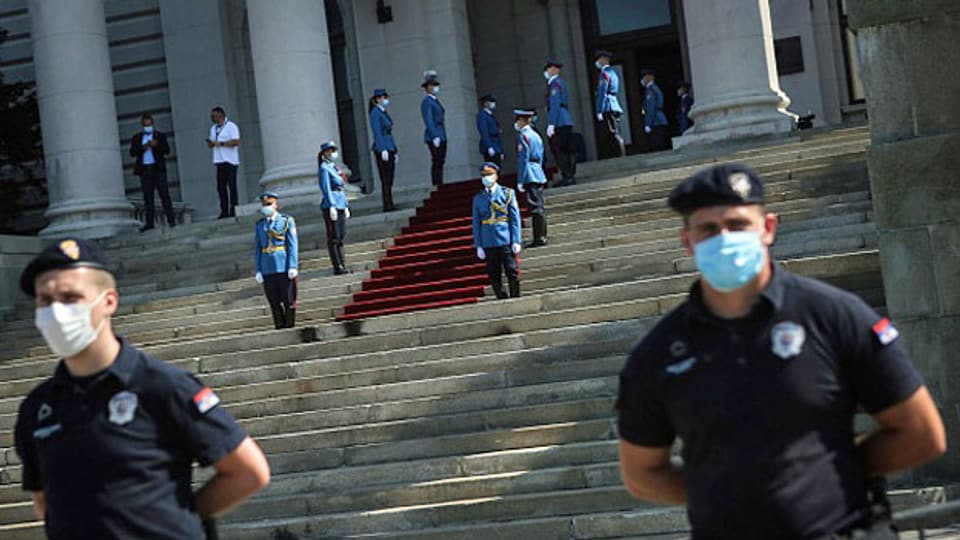 Vor dem Parlamentsgebäude vor der Eröffnungssitzung des Parlaments in Belgrad am 3. August 2020 stehen Polizeibeamte und die Ehrengarde der serbischen Armee mit Gesichtsmasken vor dem Parlamentsgebäude.