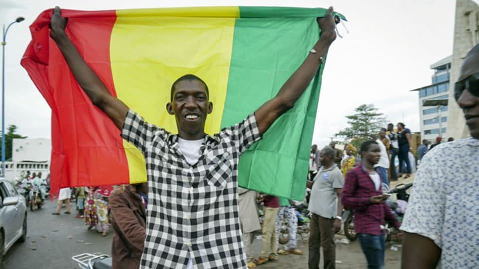 Mann mit der Nationalflagge von Mali.