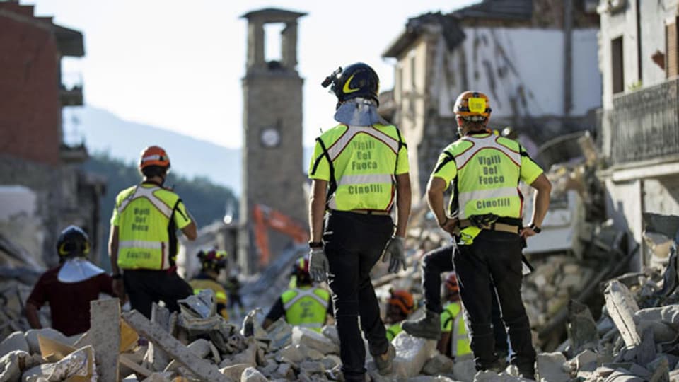 Rettungskräfte suchen nach Opfern und räumen Trümmer in der erdbebengeschädigten Stadt Amatrice in Mittelitalien auf. 29. August 2016.