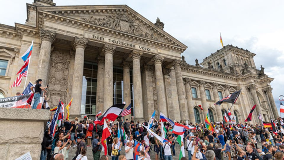 Teilnehmer einer Kundgebung gegen die Corona-Massnahmen stehen vor dem Reichstag in Berlin am 29.8.2020.