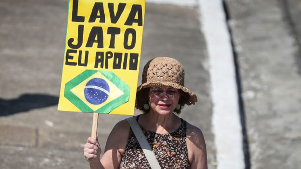 Eine Frau mit einem Plakat zur Unterstützung für die Operation «Java Lato» in Sao Paulo, Brasilien.