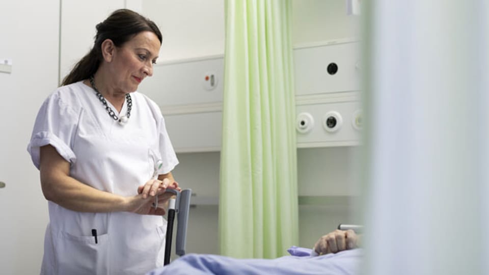 Eine Pflegefachfrau betreut einen Patienten vor einer Operation im Inselspital Bern.