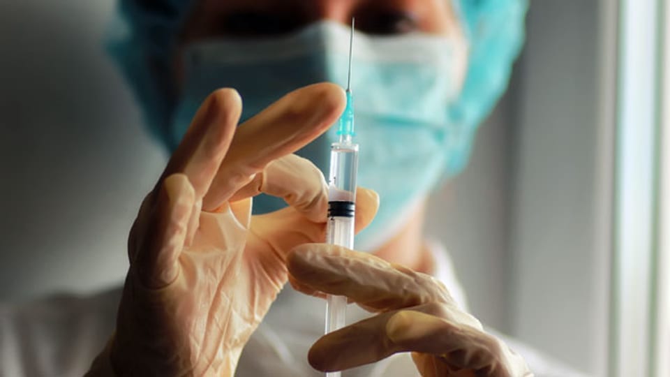 Eine Ärztin bereitet eine Impfung vor. Symbolbild