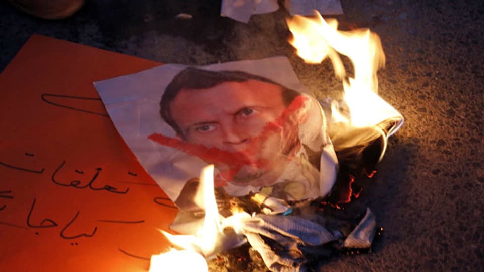 Ein Bild des französischen Präsidenten Macron wird während eines Protests in Islamabad verbrannt.
