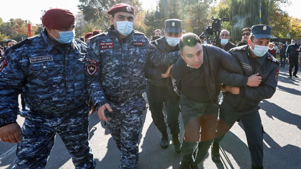 Polizeibeamte halten einen Mann fest, der an einem Protest gegen das unterzeichnete Abkommen zur Beendigung des Krieges in Berg-Karabach teilgenommen hat.