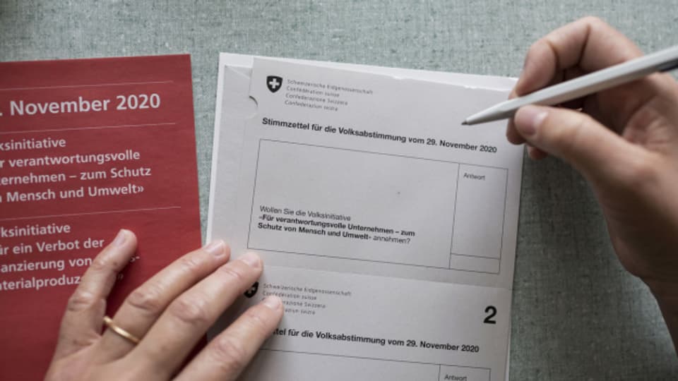 Eine Person füllt Stimmunterlagen der Eigenössischen Volksabstimmung vom 29. November 2020 aus.