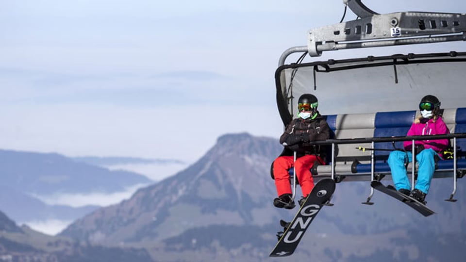 Ein Skifahrer und eine Snowboarderin fahren mit dem Sessellift «Ice Flyer» auf dem Titlis, am Dienstag, 10. November 2020.
