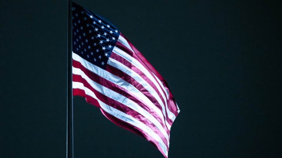 US-Flagge vor dunklem Hintergrund, hier in Berlin bei der US-Botschaft