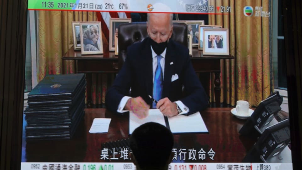 Joe Biden unterzeichnet erste Dekrete - live im Fernsehen (hier in Hong Kong).