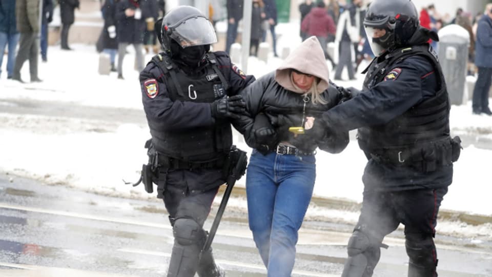 Polizisten nehmen in Moskau eine Demonstrantin fest.