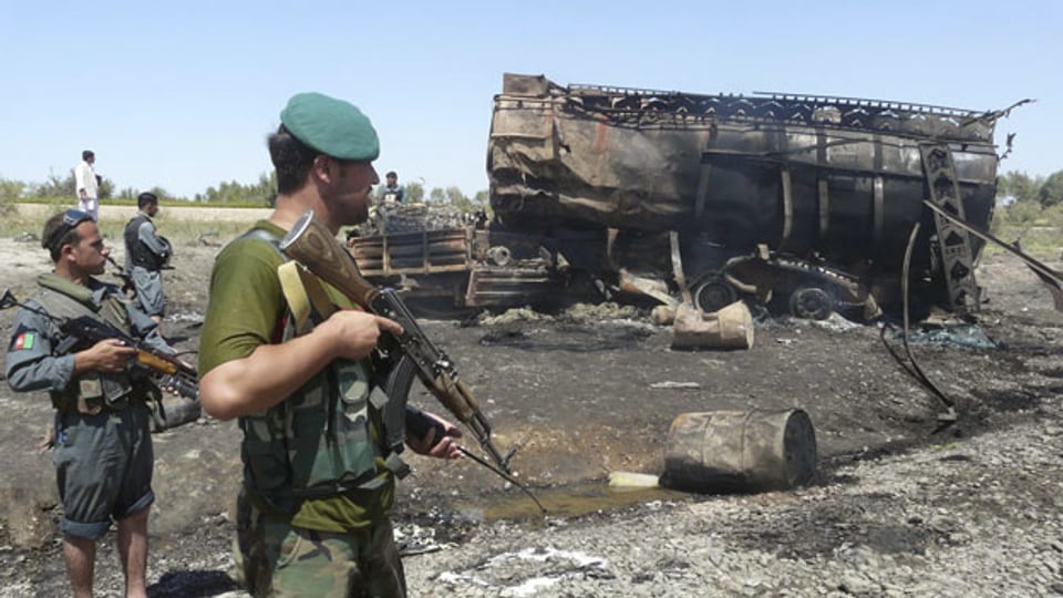 Afghanische Sicherheitskräfte stehen am 4. September 2009 neben dem Wrack eines ausgebrannten Tanklastzuges in Kunduz, der durch einen Bombenangriff zerstört wurde.