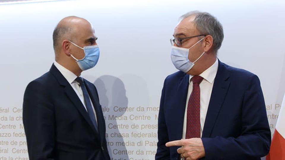 Bundesratspräsident Guy Parmelin (rechts) und Bundesrat Alain Berset sprechen nach einer Medienkonferenz des Bundesrates zu den neusten Massnahmen zur Bewältigung der Coronavirus-Pandemie am 12. März 2021 in Bern.