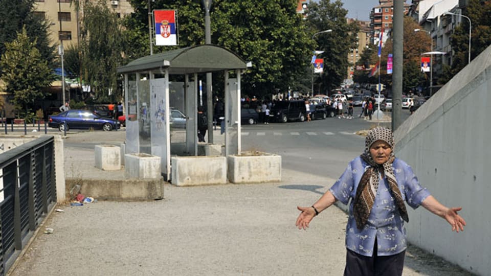 Frau auf der Brücke der ethnisch geteilten Stadt Kosovska Mitrovica, Kosovo. Archivbild vom September 2011.
