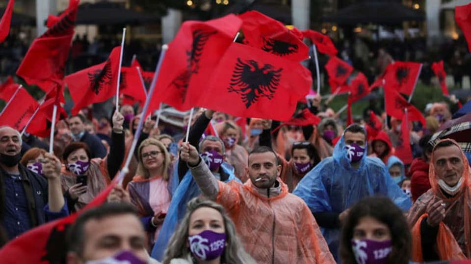 Menschen schwenken albanische Flaggen während einer Wahlkampfkundgebung der Sozialistischen Partei in Tirana, Albanien, 22. April 2021.