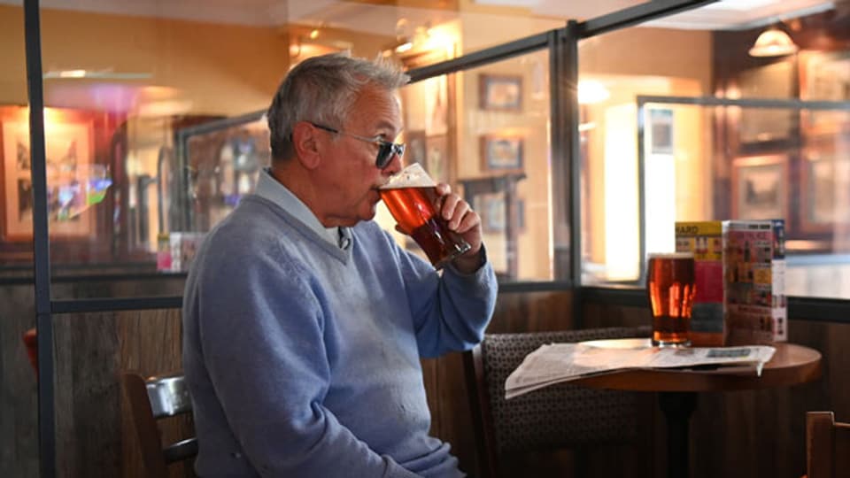 Ein Kunde geniesst ein Bier in einem Pub in London.