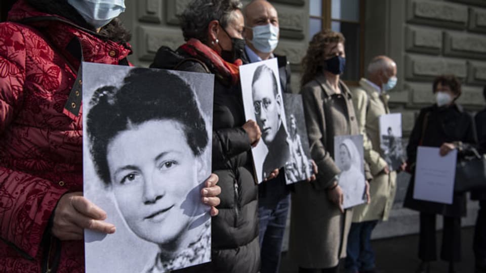 Personen zeigen Bilder von in Konzentrationslagern verstorbenen Menschen und reichen eine Petition zum Konzept für ein Schweizer Memorial für die Opfer des Nationalsozialismus ein, am 25. Mai 2021, in Bern.