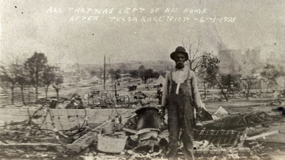 Einen Mann steht, nach dem Tulsa-Massaker inmitten der Ruinen seines Hauses in Tulsa, Oklahoma. 1. Juni 1921.