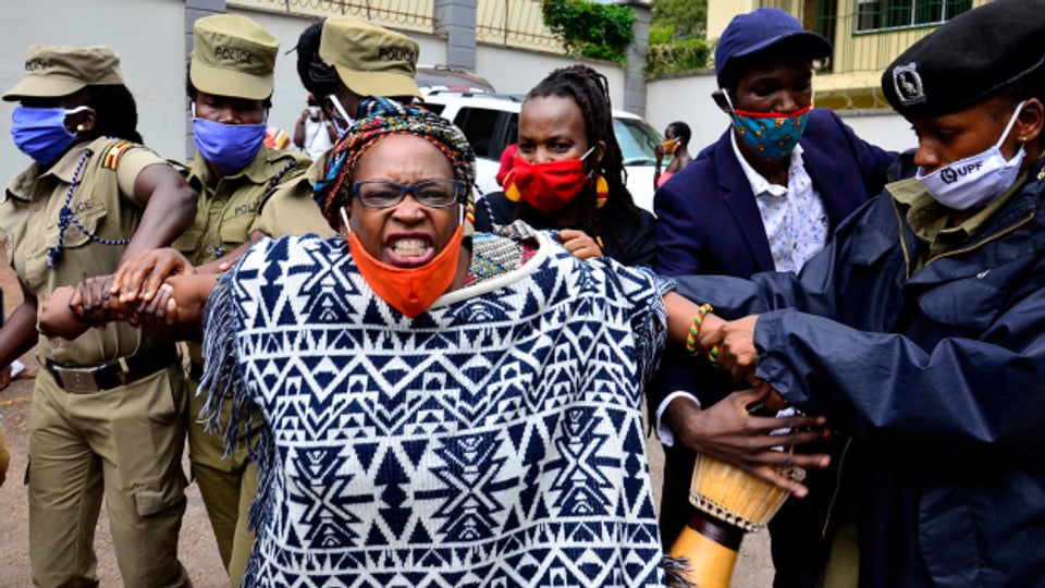 Die ugandische Oppositionelle Stella Nyanzi wird bei einem ihrer Proteste von Polizistinnen und Polizisten gepackt.