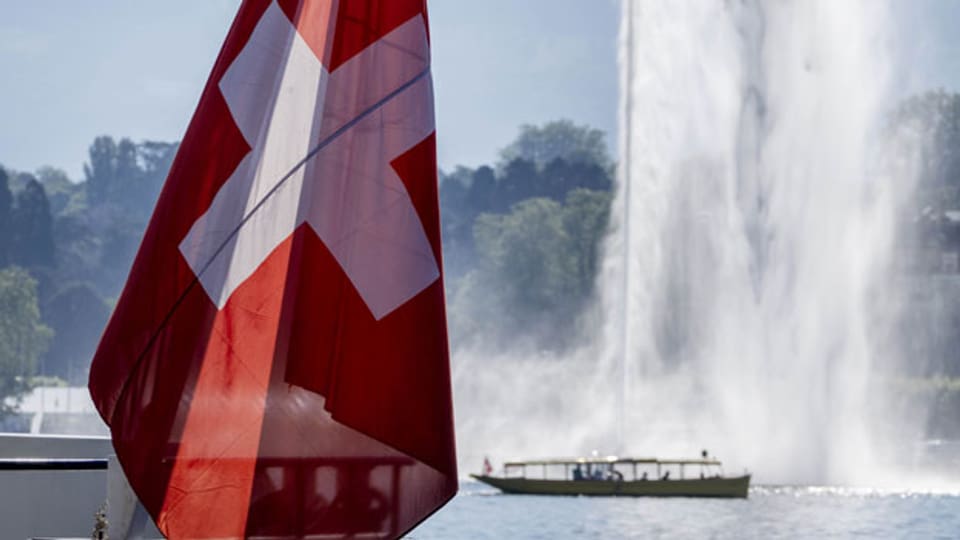 Ein Touristenboot fährt an einer Schweizer Flagge auf dem Genfersee in Genf, Schweiz, vorbei, Dienstag, 15. Juni 2021. US-Präsident Joe Biden und Russlands Präsident Wladimir Putin treffen sich am Mittwoch zu Gesprächen in Genf.