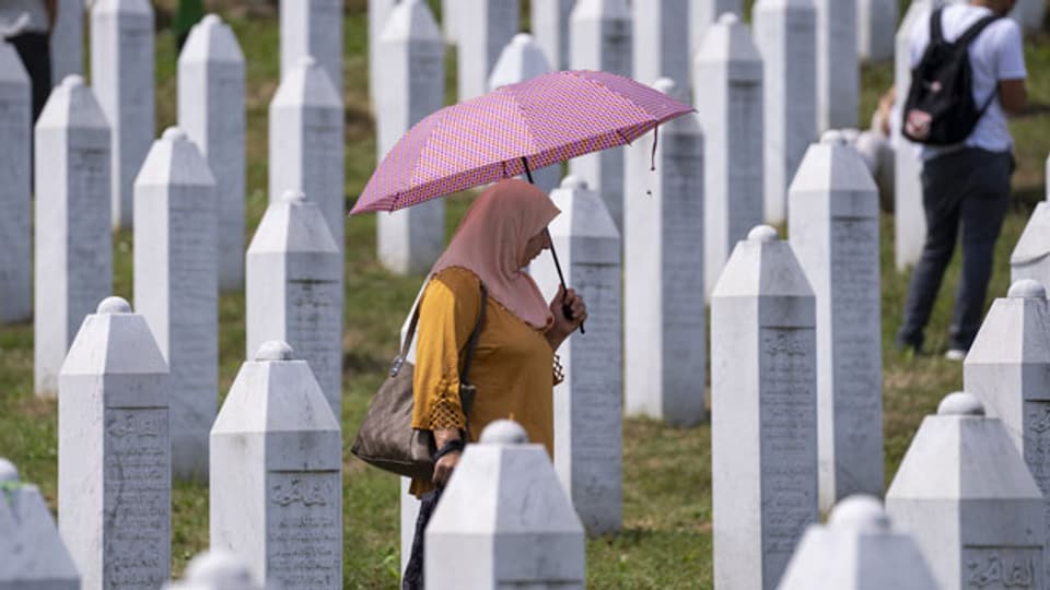 Eine Frau auf dem Gedenkfriedhof in Potocari bei Srebrenica, Bosnien.