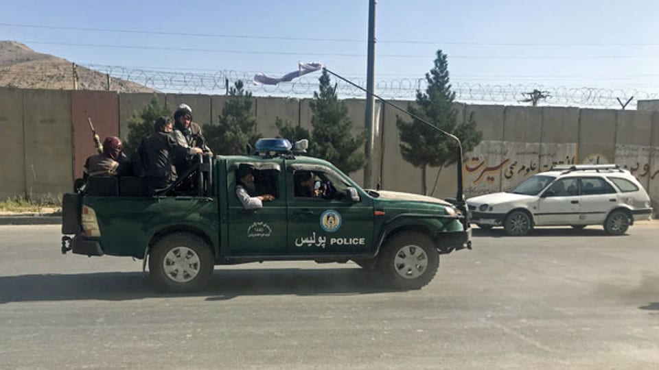 Taliban-Kämpfer fahren auf einem Polizeiauto durch Kabul.