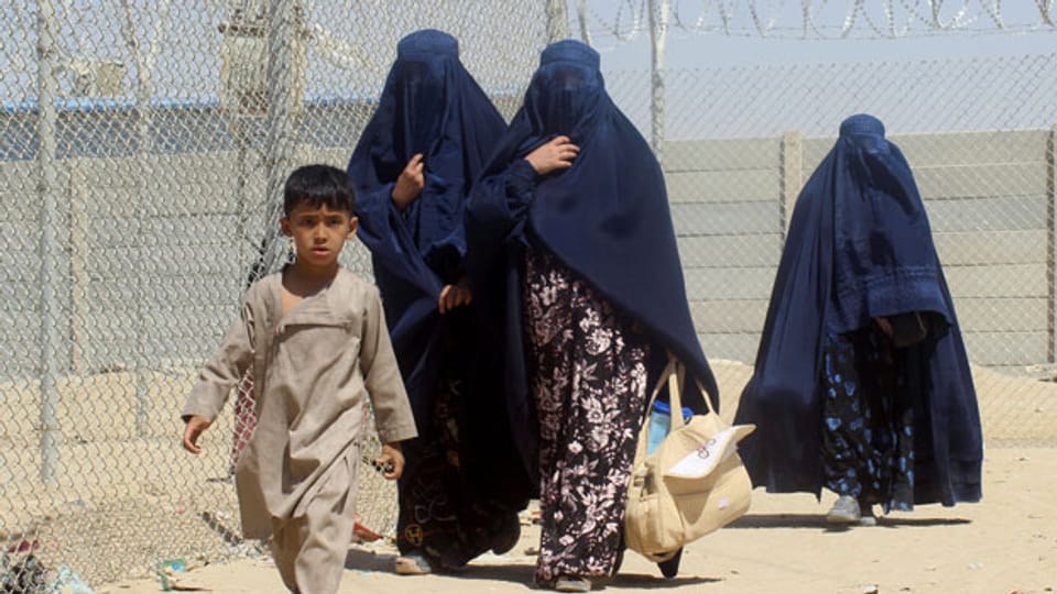 In Burkas gekleidete afghanische Frauen und ein Kind.