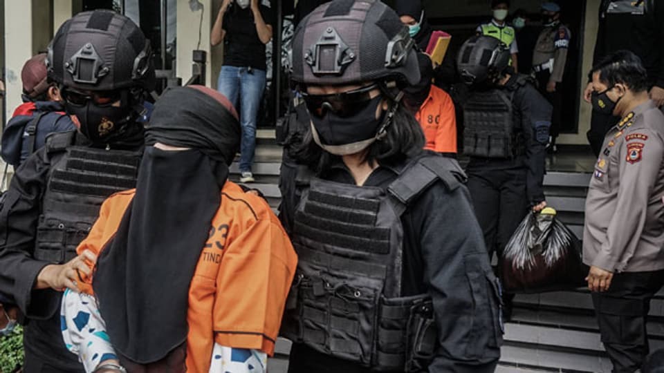 Symbolbild. Indonesische Polizisten führen eine Terroristin ab.