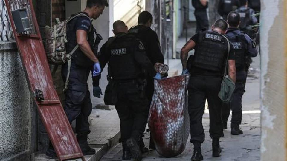 Nach der Razzia vom 6.5.2021 trägt die Polizei eine Leiche aus der Favela von Jacarezinho.