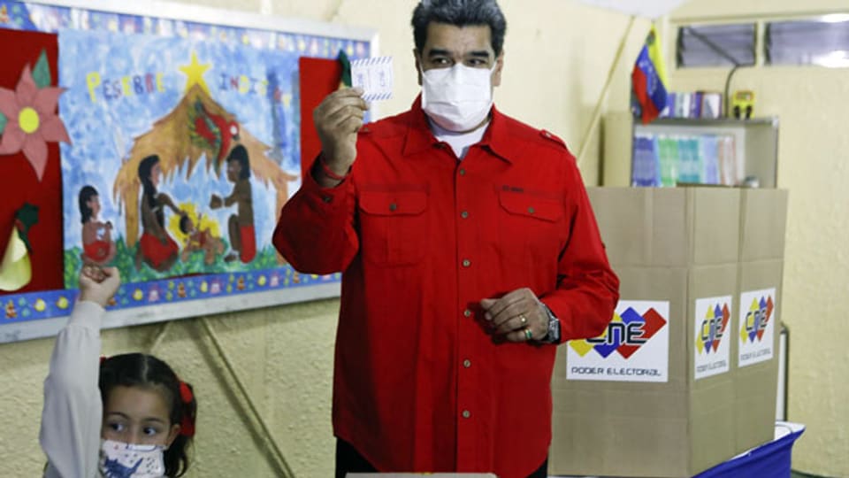 In Begleitung seiner Enkelin zeigt Venezuelas Präsident Nicolas Maduro seinen Stimmzettel.