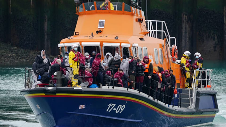 Migranten werden an Bord eines Dover-Rettungsbootes nach Dover, Kent, gebracht.