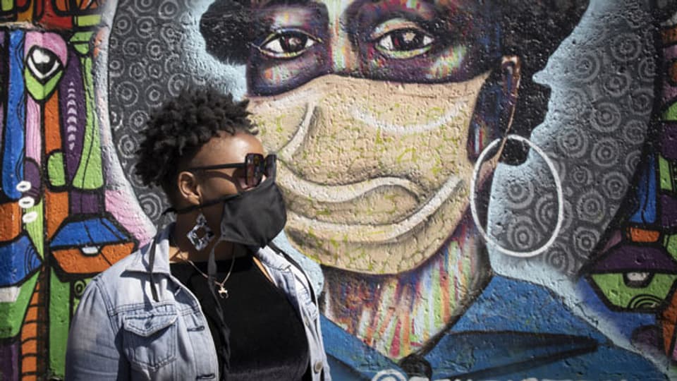 Ein Anwohner aus Soweto steht vor einem informativen Graffiti-Kunstwerk, das die Einwohner von Soweto über die Gefahren des Covid-19-Corona-Virus aufklärt, Johannesburg, Südafrika. Symbolbild.