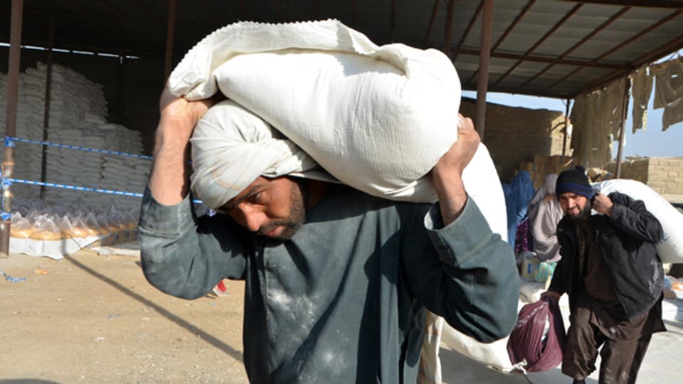 Menschen erhalten vom Welternährungsprogramm (WFP) gespendete Hilfsgüter in der Stadt Kandahar im Süden Afghanistans, 20. Dezember 2021.
