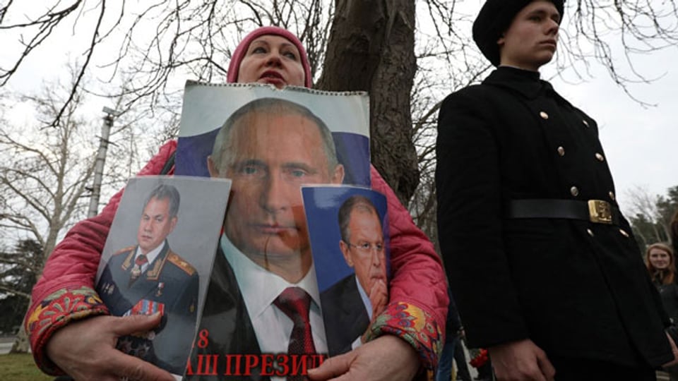 Wladimir Putin, Sergej Lawrow, Sergej Schoigu. Eine Frau auf der annektierten Krim feiert den Tag der «Verteidiger des Vaterlands».