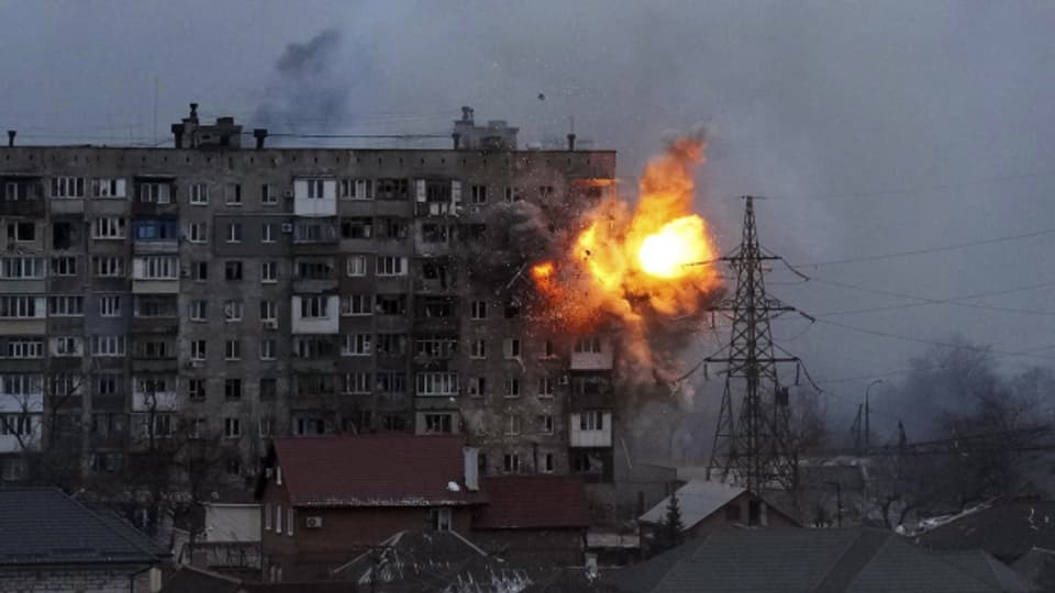 Eine Explosion ist in einem Wohnhaus zu sehen, nachdem ein Panzer der russischen Armee in Mariupol, Ukraine, am Freitag, 11. März 2022, geschossen hat.