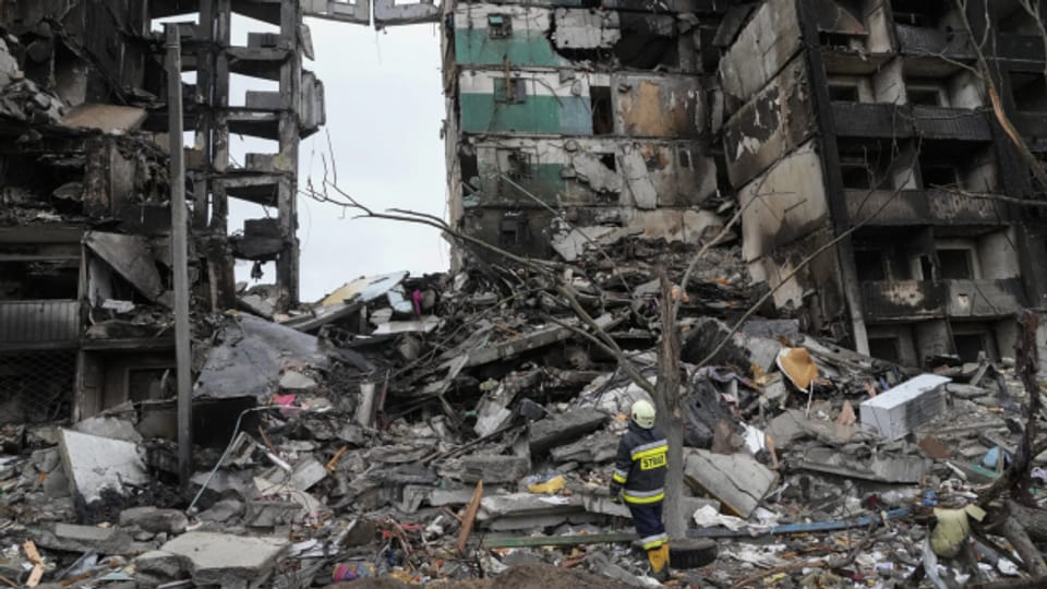 Ein Rettungssanitäter steht vor einem zerstörten Gebäude in Borodjanka, in der Nähe von Kiew, am 9. April 2022.