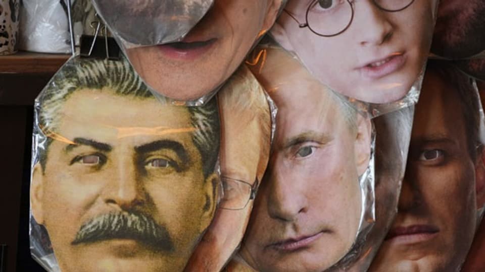 Gesichtsmasken in einem Souvenir-Geschäft in St. Petersburg zeigen (links) den sowjetischen Diktator Josef Stalin, den russischen Präsidenten Wladimir Putin (Mitte), und den inhaftierten russischen Oppositionsführer Alexei Nawalny (rechts).