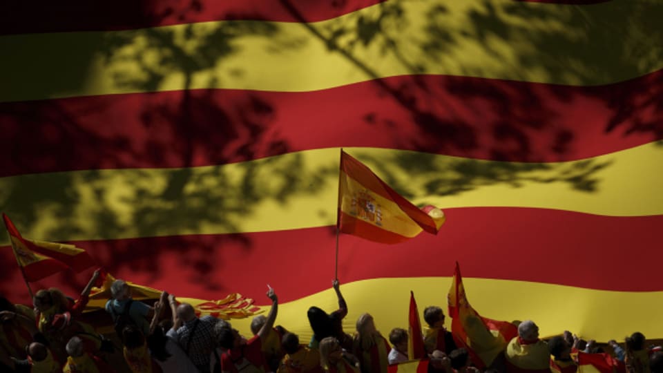 Bei einer Demonstration im Oktober 2017 in Barcelona wird eine Spanienflagge vor einer riesigen Katalonienflagge geschwenkt.