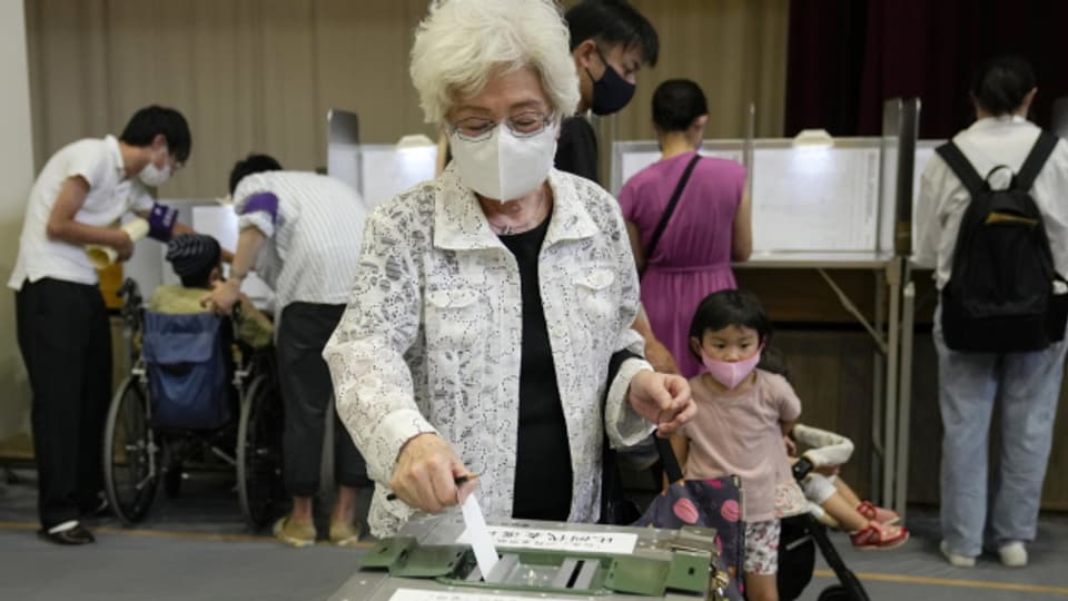 Eine Wählerin wirft ihren Stimmzettel in eine Wahlurne in Tokio, 10. Juli 2022.
