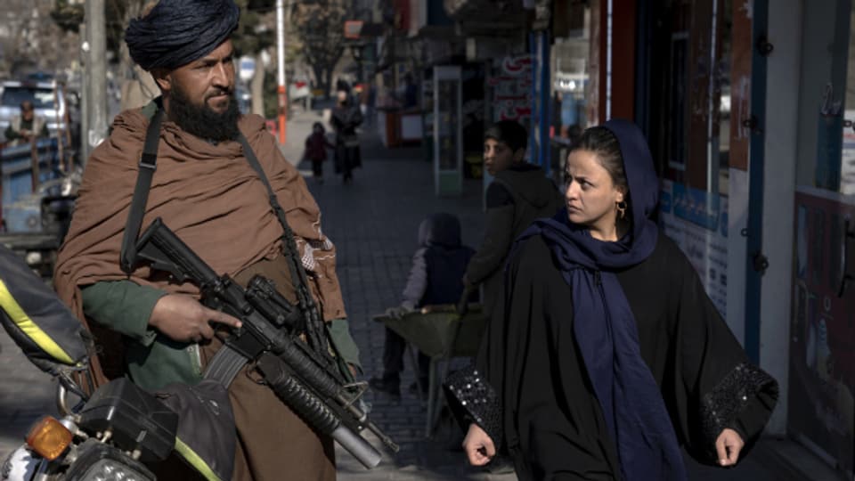 Taliban-Kämpfer und Passantin: Strassenszene in Kabul.