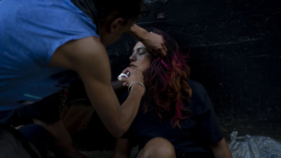 Ein Obdachloser injiziert einer Süchtigen, die offenbar eine Überdosis genommen hat, in Los Angeles ein Narcan-Nasenspray in die Nase.