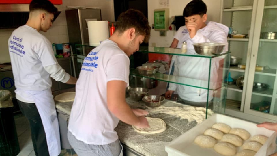 Junge Italiener lernen die Kunst des Pizzabackens.