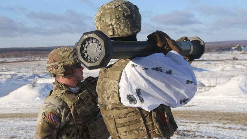 Ein US-Soldat instruiert einen ukrainischen Soldaten über den Gebrauch von Verteidigungswaffen.