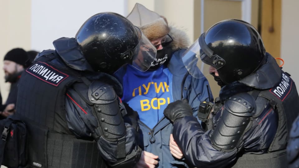 Russische Polizisten verhaften 2022 in St. Petersburg, Russland einen Teilnehmer einer nicht genehmigten Kundgebung gegen die russische Militäroperation in der Ukraine.