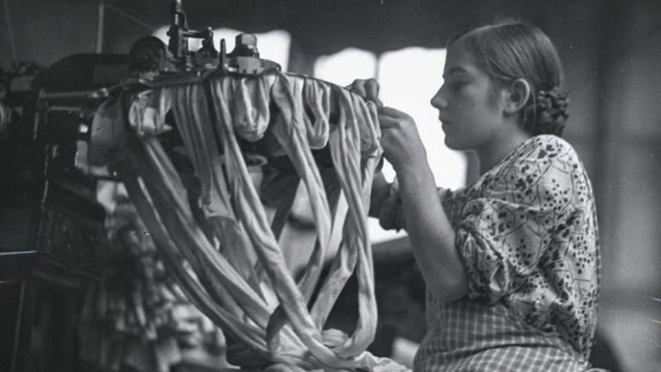Ein Mädchen bei der Arbeit in einer Zürcher Textilfabrik um 1930.